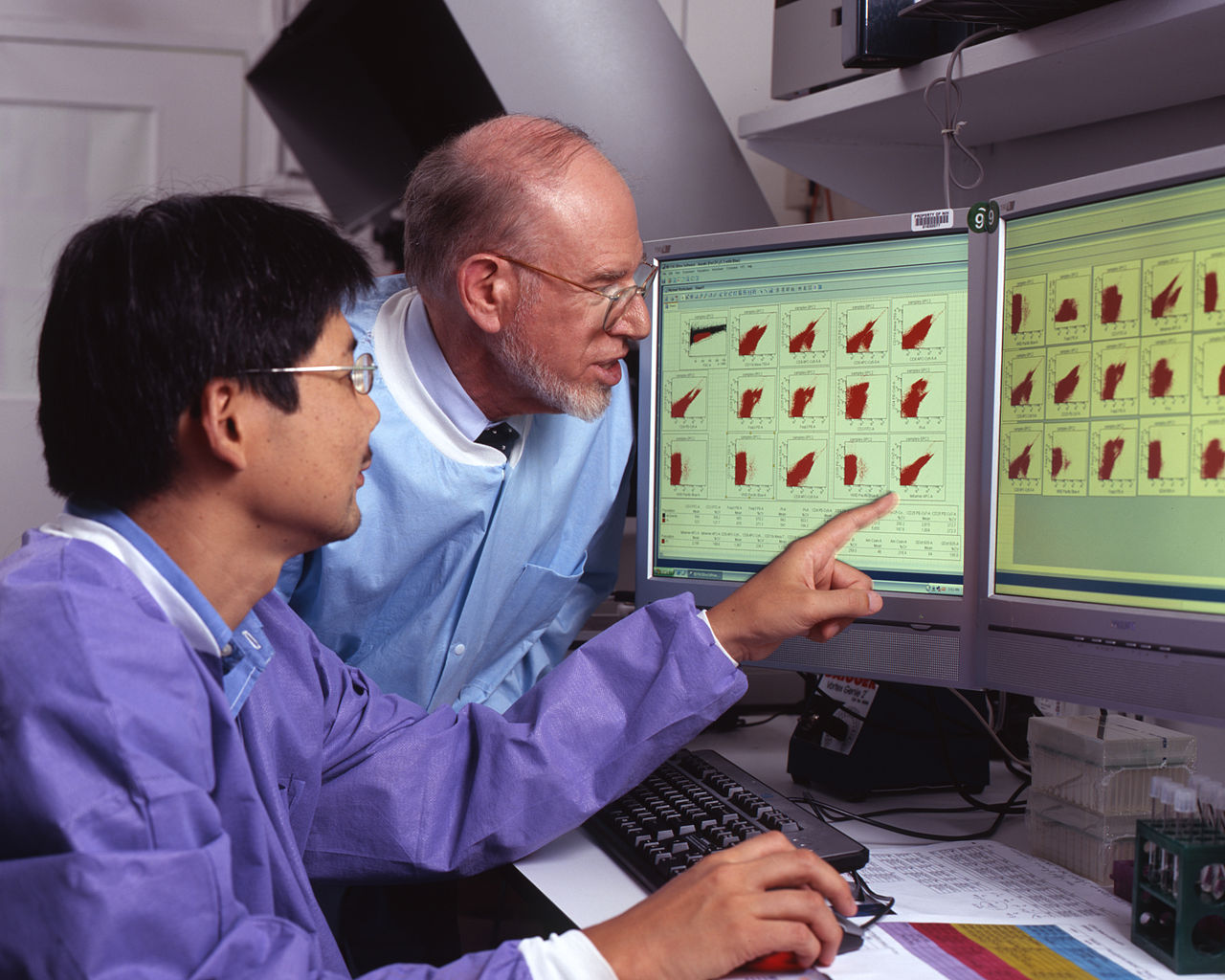 Personal del laboratorio revisando los resultados de los estudios de patología en pantalla